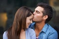 Love, kiss forehead and a happy couple outdoor for care, commitment and people in connection. Romance, man and woman Royalty Free Stock Photo