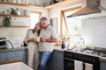 Love, kitchen and senior couple relax with cup of coffee, tea or hot drink while bonding and connect at home. Family Royalty Free Stock Photo