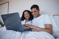 Love, laptop and happy couple relax in bed, bonding and enjoying streaming, movie or browsing in their home. Online Royalty Free Stock Photo