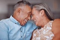 Love, laugh and happy elderly couple relax and bond in a living room, laughing and sharing a funny joke in their home