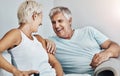 Love, laugh and retirement with a senior couple sitting in the living room of their home together. Happy, smile or relax Royalty Free Stock Photo