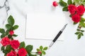 Love letter concept. Blank paper card, fountain pen, roses flowers on white marble desk. Minimal flat lay style composition, top Royalty Free Stock Photo