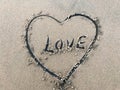 Love letter drawn in middle heart beach on sand with sea waves Royalty Free Stock Photo