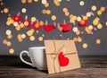 Love letter with a heart next to a cup on a background of lights  love and valentine concept on a wooden table Royalty Free Stock Photo