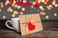 Love letter with a heart next to a cup on a background of lights  love and valentine concept on a wooden table Royalty Free Stock Photo