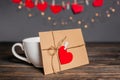 Love letter with a heart next to a cup on a background of lights  love and valentine concept on a wooden table Royalty Free Stock Photo