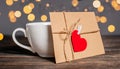 Love letter with a heart next to a cup on a background of lights  love and valentine concept on a wooden table Royalty Free Stock Photo