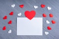 Love letter, valentine card for loved ones. Blank white sheet of paper surrounded by white and red heart shapes Royalty Free Stock Photo