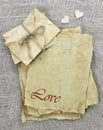 Love letters and envelopes made of antique parchment paper with wooden hearts on background
