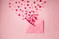 Love letters. Pink envelope with  red hearts inside on  pink background Royalty Free Stock Photo