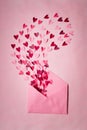 Love letters. Pink envelope with  red hearts inside on  pink background Royalty Free Stock Photo