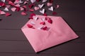 Love letters. Pink envelope with  red, white and pink hearts inside on grey wooden  background Royalty Free Stock Photo