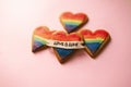 Love is love LGTB hearts cookies on a pink background. Rainbow heart cookie. Heart lgbt+ sign rainbow color stripe. Symbolic free Royalty Free Stock Photo