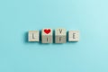 LOVE, LIFE text and red heart on Wooden cubes on blue background Royalty Free Stock Photo