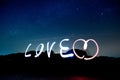 Love light paining alphabet over Stars in the night sky background. Royalty Free Stock Photo