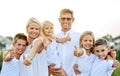 Love makes a family thumbs up. a happy family with their thumbs up outdoors. Royalty Free Stock Photo