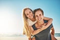 Love makes summer even more awesome. a happy young couple enjoying a piggyback ride at the beach. Royalty Free Stock Photo