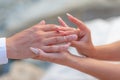 Love and marriage. Wedding ceremony. Close up of bridge putting golden ring on the groom`s finger Royalty Free Stock Photo