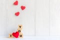 Love message written in wooden blocks with red heart, white wood background. Royalty Free Stock Photo