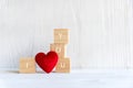 Love message written in wooden blocks with red heart, white wood background. Royalty Free Stock Photo