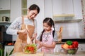 Love moment of Asian family mom and daughter helping preparing vegetable salad in kitchen at home Royalty Free Stock Photo