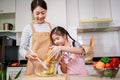 Love moment of Asian family mom and daughter helping preparing vegetable salad in kitchen at home