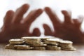 Greedy hand grabbing or reaching out for pile of golden coins. Close up - Concept for tax, fraud and greed Royalty Free Stock Photo