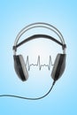 Love music concept. Wireless black headphones with cardiogram isolated on blue background