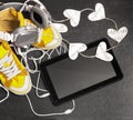 Love for music concept. Yellow sneakers, headphones, tablet,hearts.