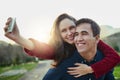 Love my babe to the moon and back. a young couple taking selfies while enjoying a piggyback ride outdoors. Royalty Free Stock Photo