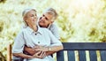 Love, nature and elderly couple hugging while sitting on an outdoor bench in the park. Happy, care and senior man Royalty Free Stock Photo