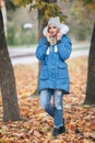 In love with nature, a girl in a jacket walks through the autumn park. warm clothes for the autumn season