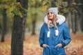 In love with nature, a girl in a jacket walks through the autumn park. warm clothes for the autumn season