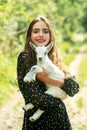 Love nature. Happy smiling girl with lamb on a countryside. Young woman hugging a small goatling at farm. Royalty Free Stock Photo