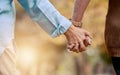 Love, nature and senior couple holding hands while walking in autumn park, forest or woods for retirement leisure Royalty Free Stock Photo