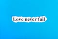 Love never fail text on paper. Word Love never fail on torn paper. Concept Image
