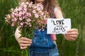 Love never fails - woman with pink flowers and calligraphy text on paper