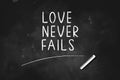 LOVE  NEVER FAILS  written with chalk on blackboard icon logo design vector illustration Royalty Free Stock Photo