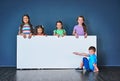 We love it and other kids will too. Studio shot of a diverse group of kids standing behind a large blank banner against Royalty Free Stock Photo