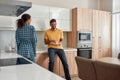 We love our home. Happy multicultural couple in casual clothes wiping the dishes and talking with each other while Royalty Free Stock Photo