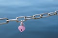 Love padlocks in pink hanging on metal chain fence Royalty Free Stock Photo