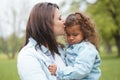 Love, park and mother kiss child with upset, sad and unhappy expression on face for leaving playground. Family, support