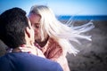 Love and passion concept for beautiful young people - girlfriend and boyfriend kissing together with outdoor nature and sea in