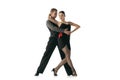 Grace and beautiful dancers, young couple dancing Argentine tango isolated on white studio background. Artists in black Royalty Free Stock Photo