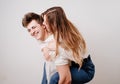love, passionate and beautiful couple have fun and cuddle against the white wall
