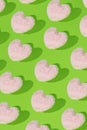 Love pattern made with pink hearts against light green pastel background. Creative Valentine`s Day concept. Flat lay Royalty Free Stock Photo