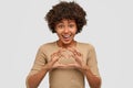 Love and peace to you. Kind happy young beautiful Afro American woman shows heart sign over chest, demonstrates