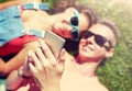 Happy teenage couple smartphone lying on grass