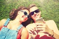 Happy teenage couple smartphone lying on grass