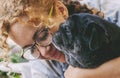 Love people and dog animal concept with happy adult caucasian woman and black old pug hugging and loving with tendernes together. Royalty Free Stock Photo